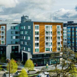Multi-Family Housing in Seattle's Yesler Terrace. A park is in the foreground and white fluffy spring clouds are in the top of the photo.